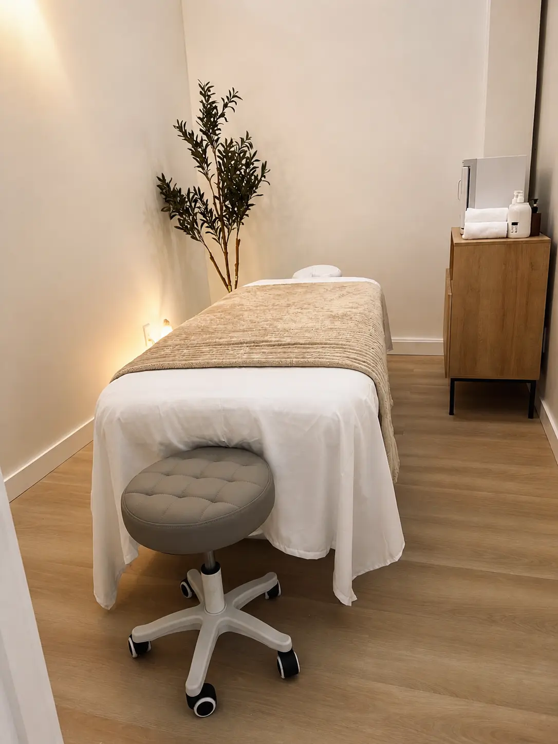 Treatment room at Harbor Wellness Massage, table turned down under warm light